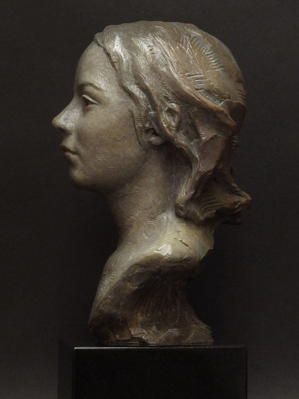 Bronze bust of young girl. Profile view. 