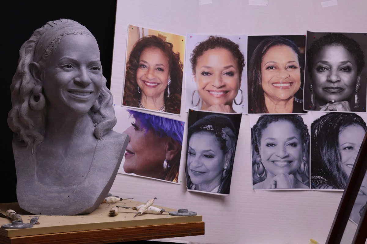 Debbie Allen Bust in Studio in clay with some of the images used to sculpt her. Poway, CA. Sculptor Richard Becker